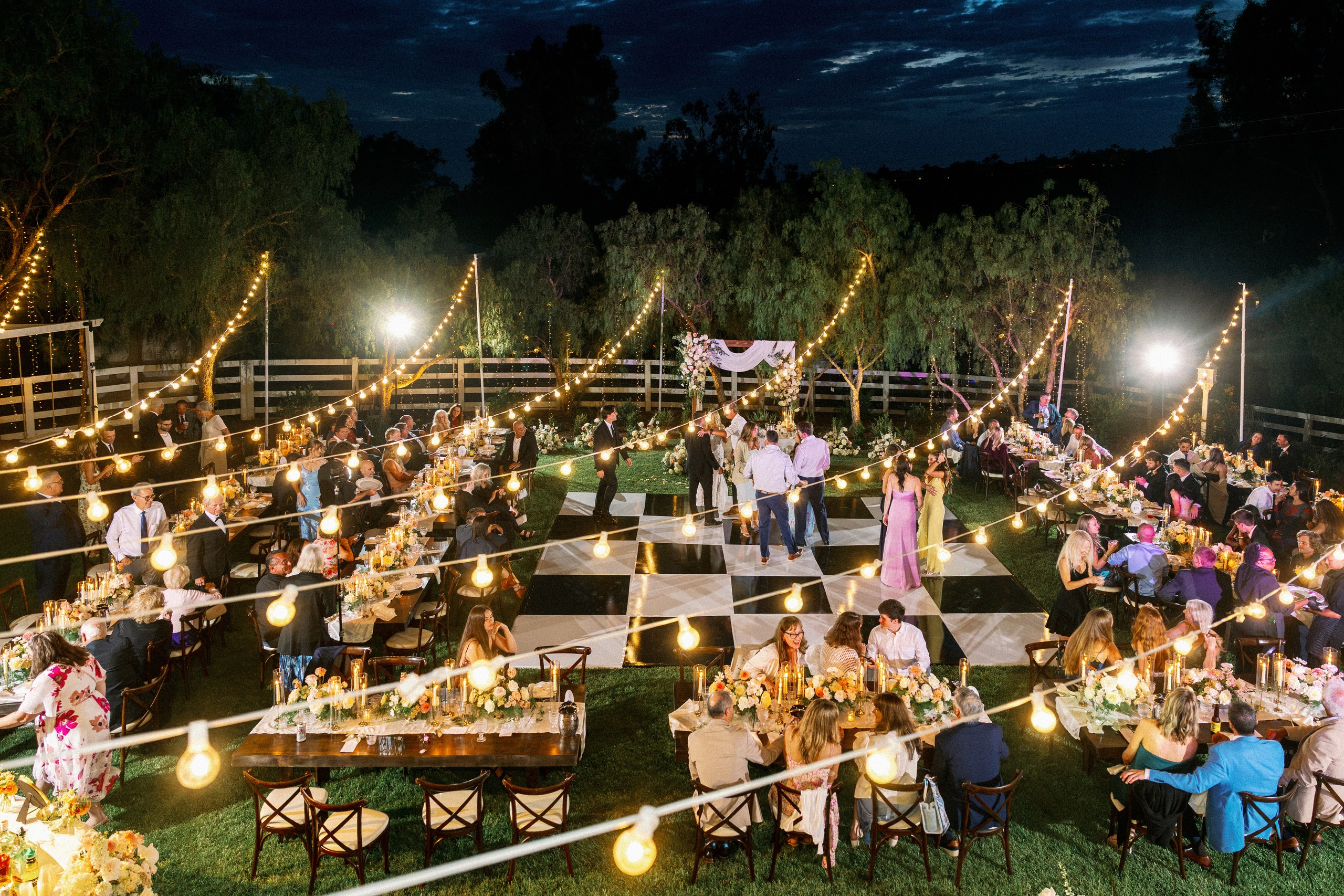 Backyard wedding reception glowing under string lights at night in Olivenhain, Encinitas