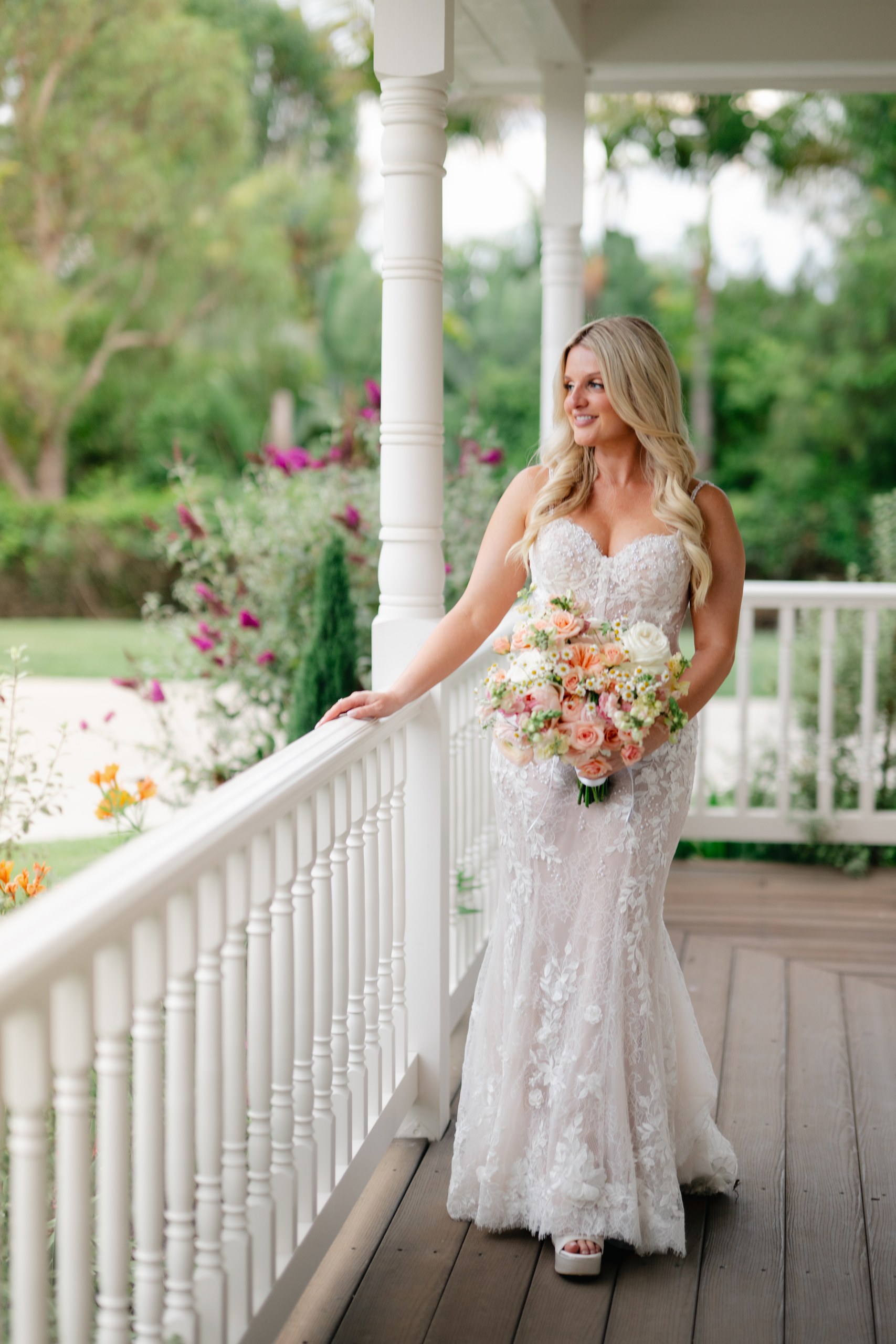Bride with a peach and pink bouquet on the front porch at her Olivenhain backyard wedding