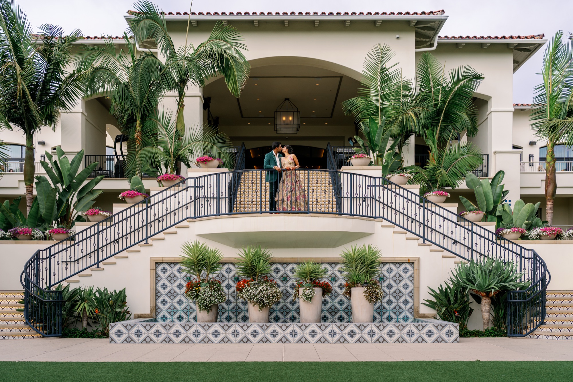 Bride and groom kissing on the grand staircase at Park Hyatt Aviara Resort in Carlsbad