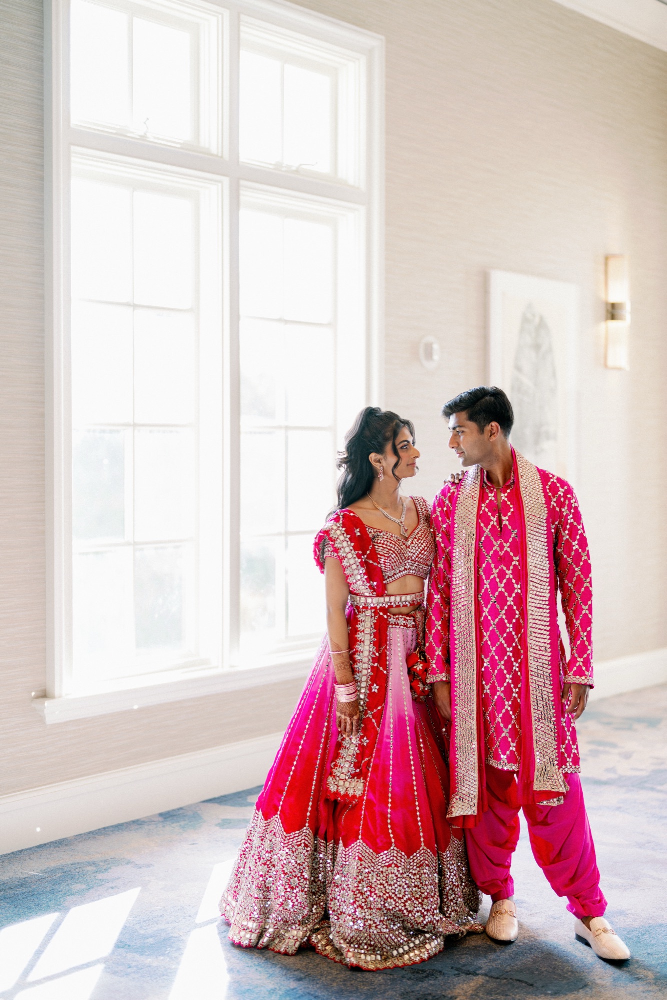 Couple in hot pink sangeet outfits at their Park Hyatt Aviara Indian wedding